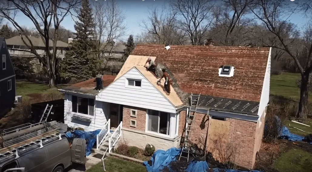 The roof of a house is being re-roofed by Revived Exteriors.