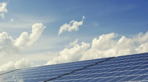 A solar panel installed by Revived Exteriors is shown against a blue sky.