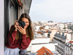 A woman taking a picture with her camera on a balcony in Chicago IL 60634.