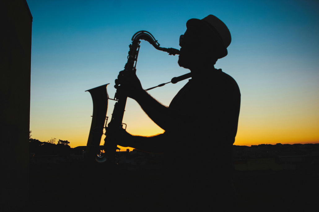 A silhouette of a man playing a saxophone at sunset. Auto Draft